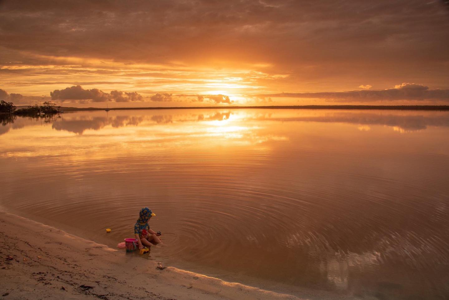 child on beach at sunset